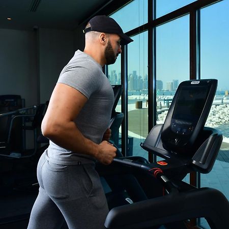 Mina Hotel And Residences By The Torch Доха Екстер'єр фото A man exercising on a treadmill