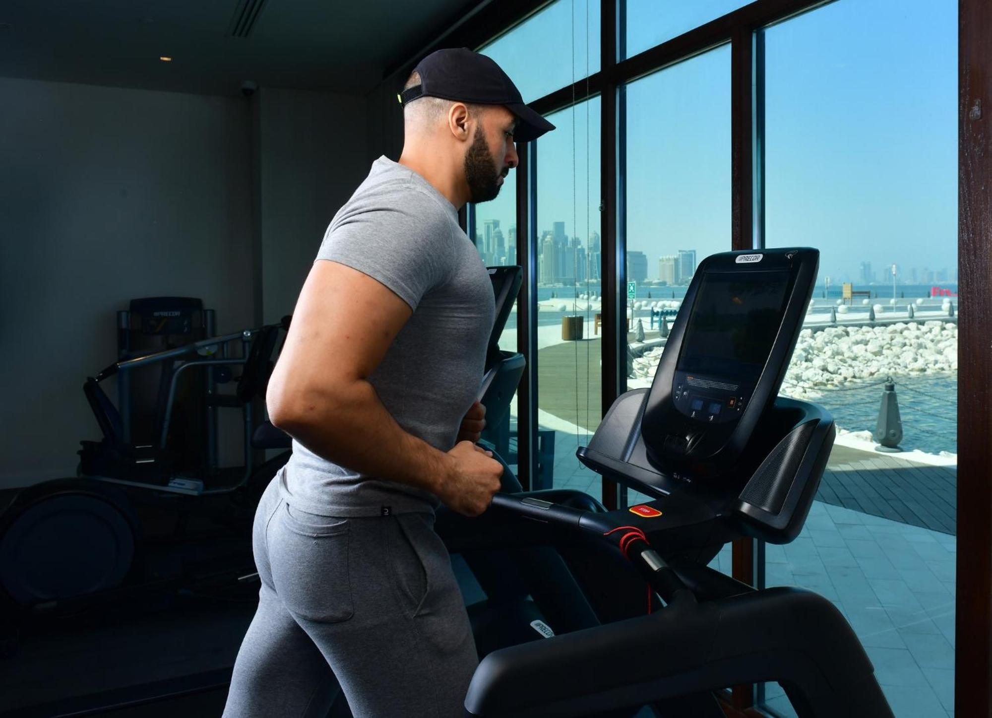 Mina Hotel And Residences By The Torch Доха Екстер'єр фото A man exercising on a treadmill